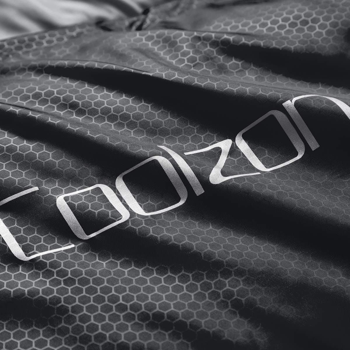 Durable hex-pattern polyester shell of sleeping bag with Coolzon logo, built for weather-resistant camping.
